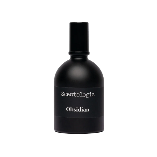A sleek black bottle of Obsidian Eau de Parfum by Scentologia, featuring a matte finish and white text against a light backdrop, captures an alluring essence and ensures a long-lasting fragrance experience.