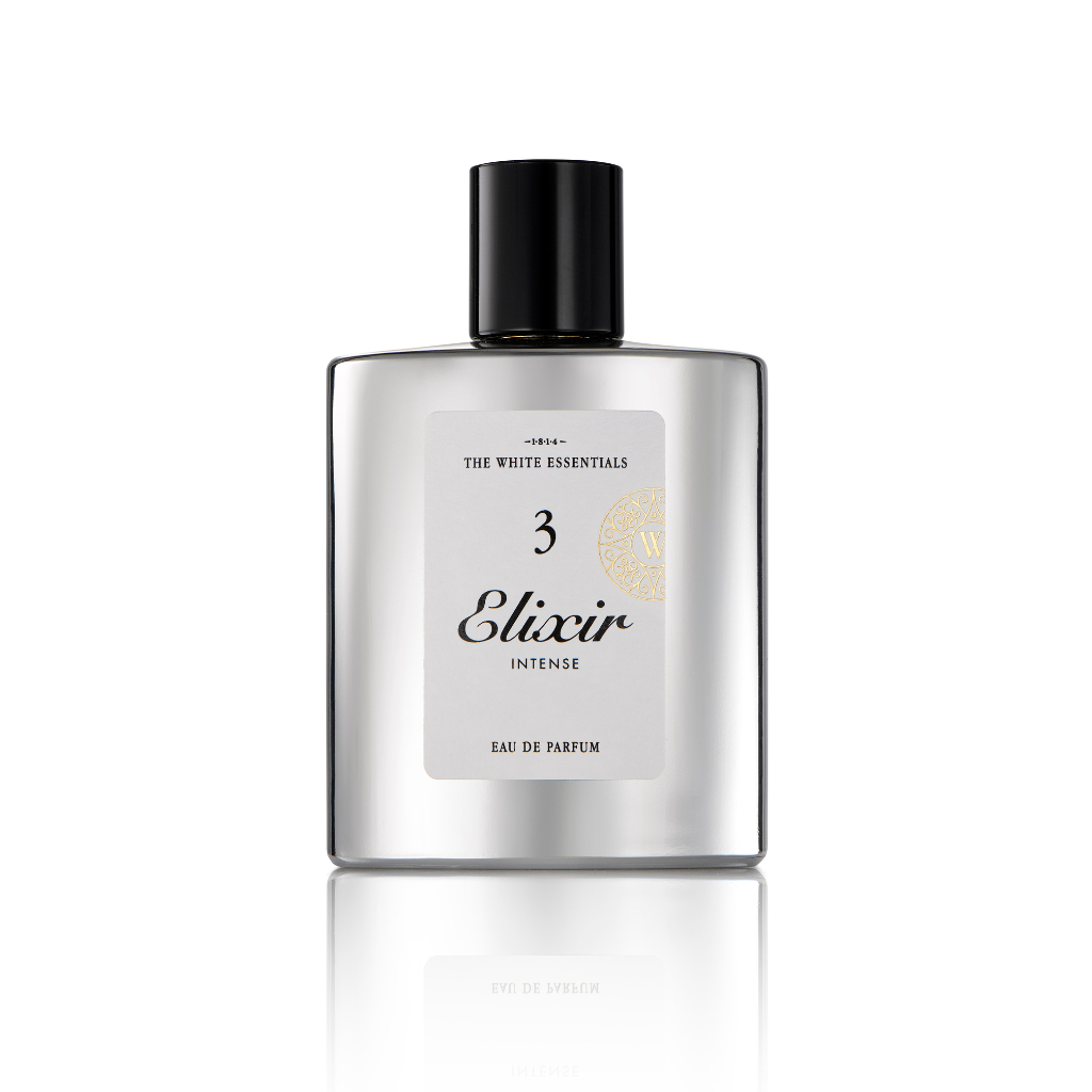 A silver rectangular bottle with a black cap, labeled Elixir 3 Intense Eau de Parfum by Jardin De Parfums, stands on a reflective white surface, evoking the essence of agarwood with elegant leather and cedar notes.