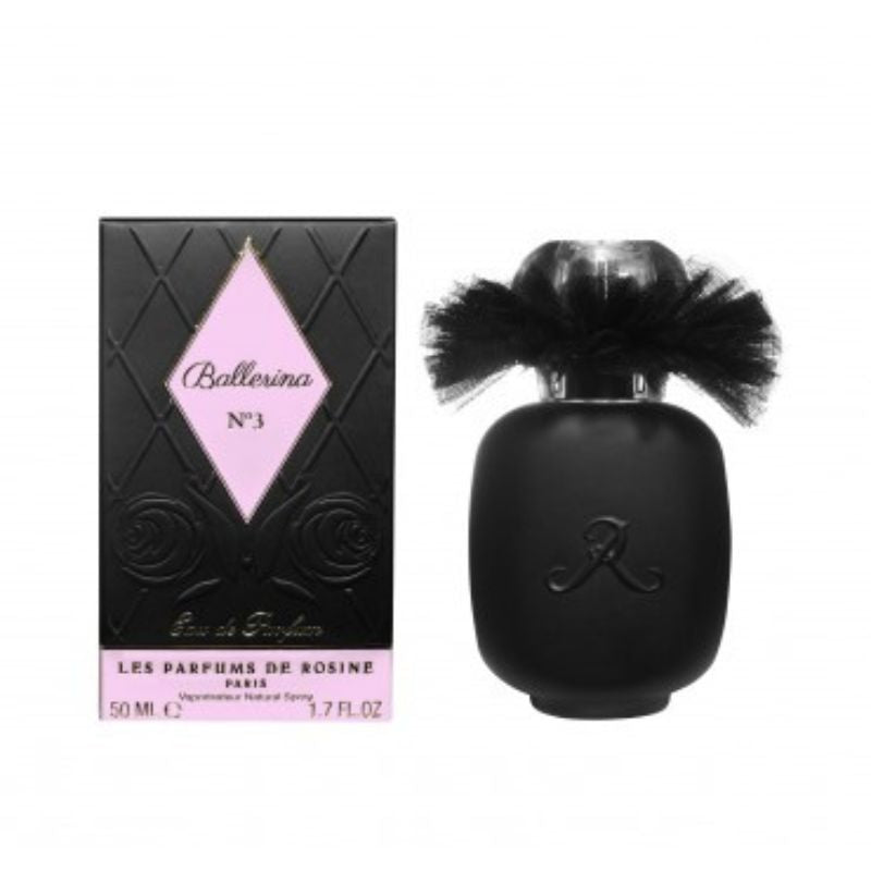 A black BALLERINA N°3 Eau de Parfum bottle with a tulle collar stands beside its diamond-patterned, rose-embossed box, both by LES PARFUMS DE ROSINE—a captivating rose scent from the Ballerina Collection.