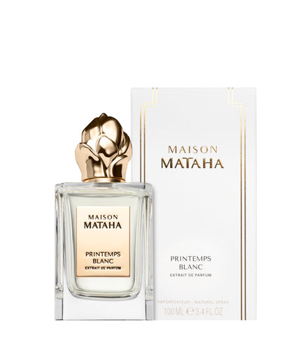 A clear glass bottle of Maison Mataha’s Printemps Blanc Extrait de Parfum stands before its white and gold box. This elegant 100 ml fragrance blends jasmine sambac notes for a fresh, sophisticated floral scent.
