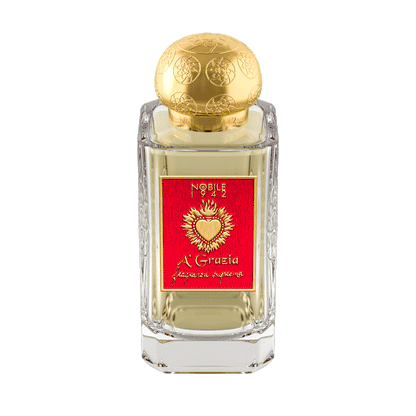 A clear glass perfume bottle with a gold embossed cap and red label displays “A' GRAZIA 'SAN GENNARO, TAKE CARE OF IT!' Eau de Parfum – Nobile 1942,” inspired by San Gennaro and Neapolitan culture, set against a solid brown background.