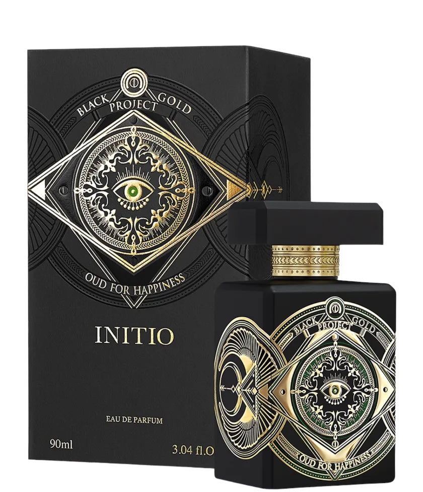 A black bottle of INITIO Oud For Happiness Eau de Parfum, detailed with gold and green eyes, is displayed before its box—a woody spicy fragrance by INITIO, 90ml.