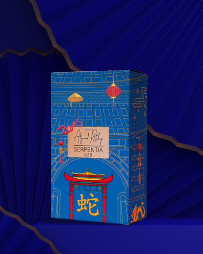 A blue rectangular box with Asian-inspired lanterns, arches, and a red gate, labeled Alfred Ritchy SERPENTIA Eau de Parfum, celebrates the Year of the Snake with a gold snake and Chinese character near the base.