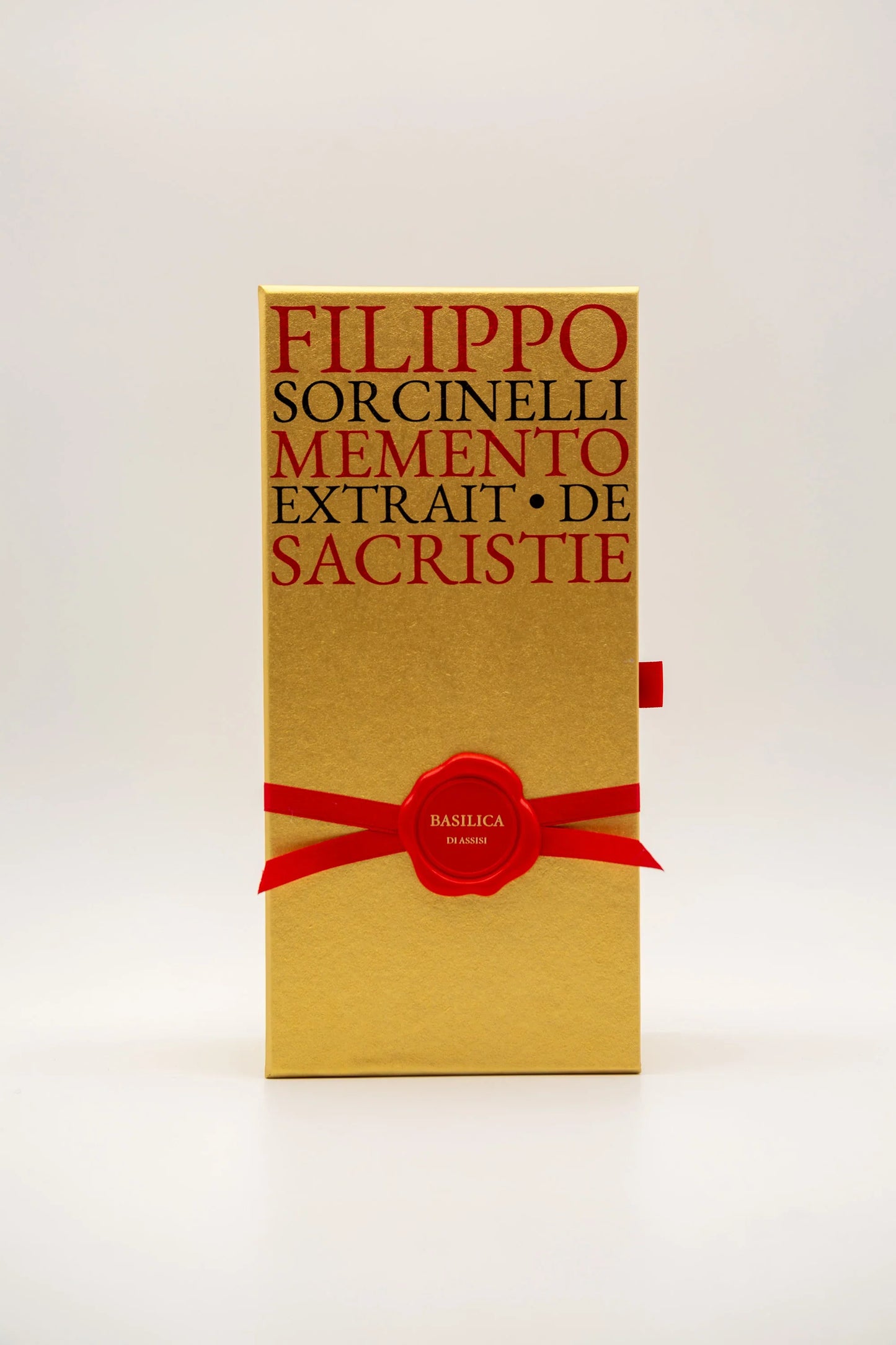 A gold box with red text reading FILIPPO SORCINELLI PONT. MAX. Eau de Parfum and a red ribbon with wax seal labeled BASILICA 85 ML evokes the rich scent of resin incense and myrrh, standing upright on a plain white background.