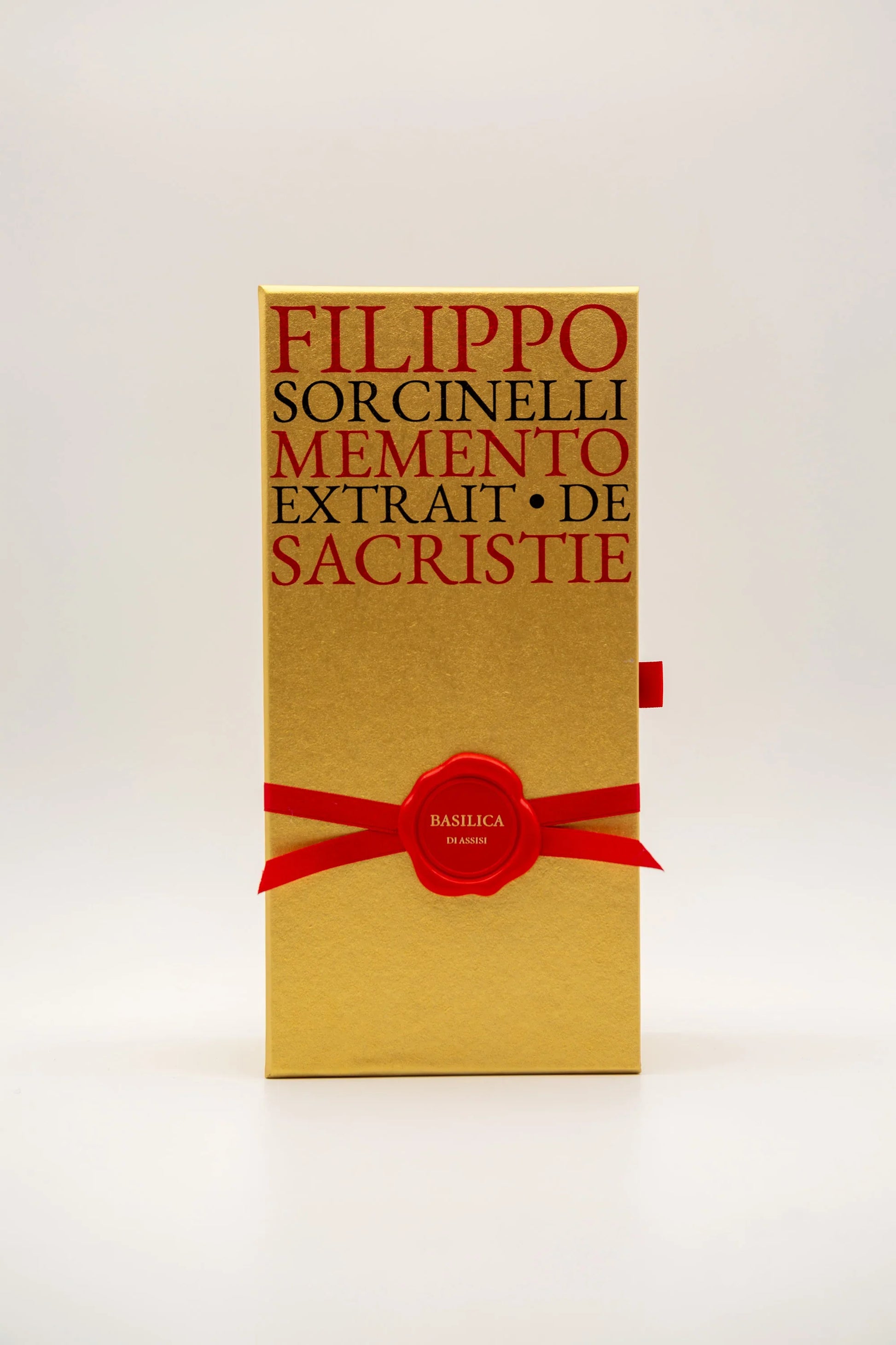 A gold box with red text reading FILIPPO SORCINELLI PONT. MAX. Eau de Parfum and a red ribbon with wax seal labeled BASILICA 85 ML evokes the rich scent of resin incense and myrrh, standing upright on a plain white background.