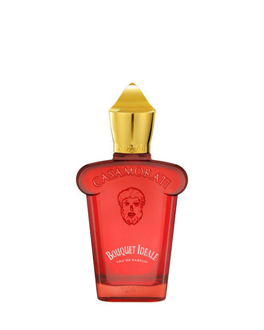 A red Bouquet Ideale Eau de Parfum bottle by Fragrapedia Haus features a gold cap, wide shoulders, and an artistic face illustration, blending bold elegance with creative design.