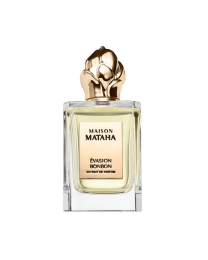 The Maison Mataha Evasion Bonbon Extrait de Parfum features pale gold liquid in a clear glass bottle with a sculpted gold floral cap, evoking the essence of a sweet treat—all set against a white background.