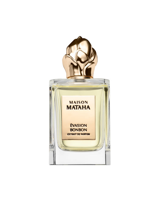 The Maison Mataha Evasion Bonbon Extrait de Parfum features pale gold liquid in a clear glass bottle with a sculpted gold floral cap, evoking the essence of a sweet treat—all set against a white background.