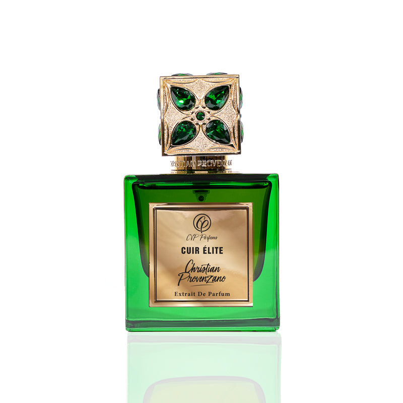 A green glass bottle with a gold label reading Cuir Elite Eau de Parfum by Christian Provenzano features an ornate gold cap accented with green gems, emphasizing the fragrance’s luxury against a crisp white background.