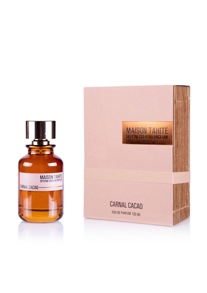 The amber-hued Carnal Cacao Eau de Parfum by Maison Tahite, with its brown cap, is shown beside its textured beige box—both labeled with the fragrance name and hinting at the rich cocoa-inspired scent inside.
