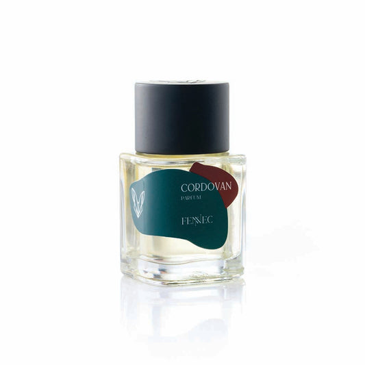 Cordovan Parfum by Fennec comes in a clear glass bottle with a black cap. A dark green label with a white fennec fox logo references the North African fox, standing out against the crisp white background.