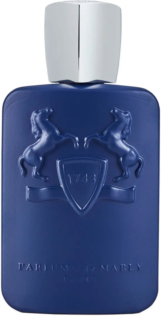 The Percival Eau de Parfum by Parfums de Marly comes in a blue bottle with embossed rearing horses and a 1743 shield, finished with a shiny silver cap. This elegant fragrance features woody spice notes.