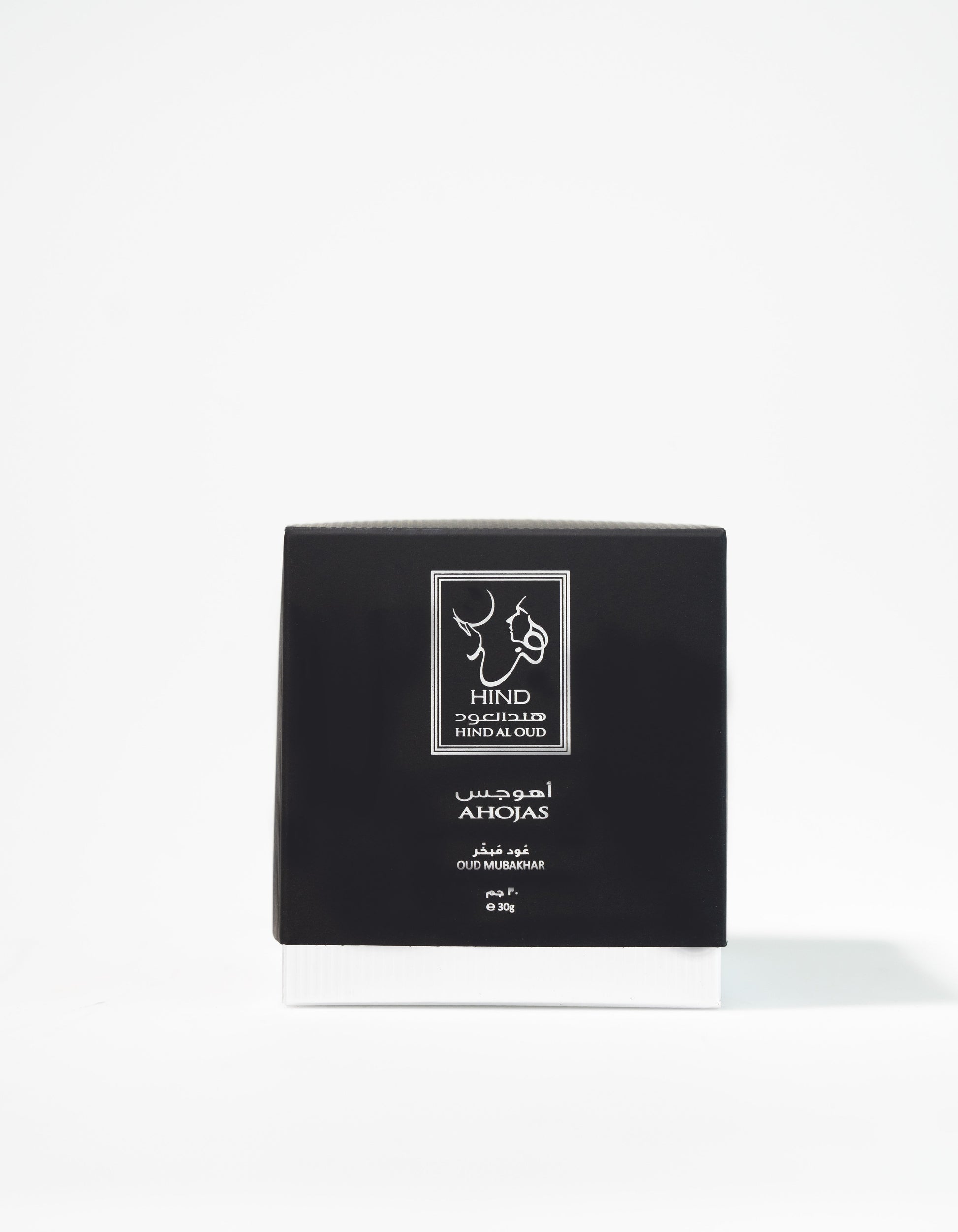 A black and white box labeled "Ahojas Oud Mubakhar - Hind Al Oud" by Hind Al Oud stands upright against a plain white background, evoking the rich allure of oud perfume.
