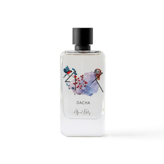 A clear 100ml DACHA Eau de Parfum bottle by Alfred Ritchy, featuring colorful abstract bird and berry art on the front, a sleek black cylindrical cap, and “Alfred Ritchy” at the base.
