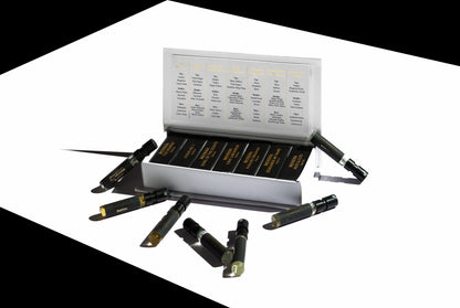 The Discovery Set - Moseha by Moseha features labeled black 1.5 ml vials, neatly arranged in a white box and on a white surface, each containing samples of their finest fragrances.