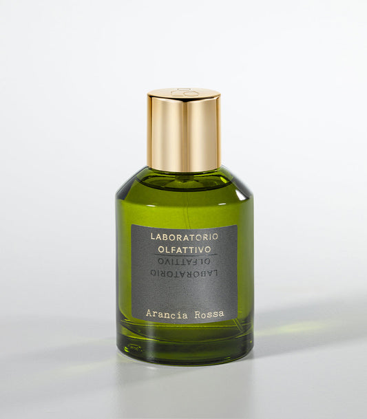 A green glass bottle of Laboratorio Olfattivo’s Arancia Rossa Eau de Parfum, featuring a gold cap and vibrant mandarin and bergamot notes, is set against a plain light gray background.