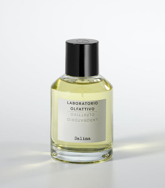 A clear glass bottle of Salina Eau de Parfum by Laboratorio Olfattivo, filled with yellow liquid and topped with a black cap, stands against a white background, capturing the fresh aquatic allure of this signature scent.