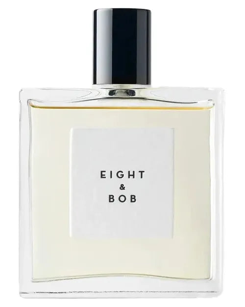 A clear glass men's perfume bottle from Fragrapedia Haus features a black cap and a white label reading "Eight and Bob." The pale yellow liquid inside is Eight and Bob Eau de Parfum, evoking an aromatic masculine scent.