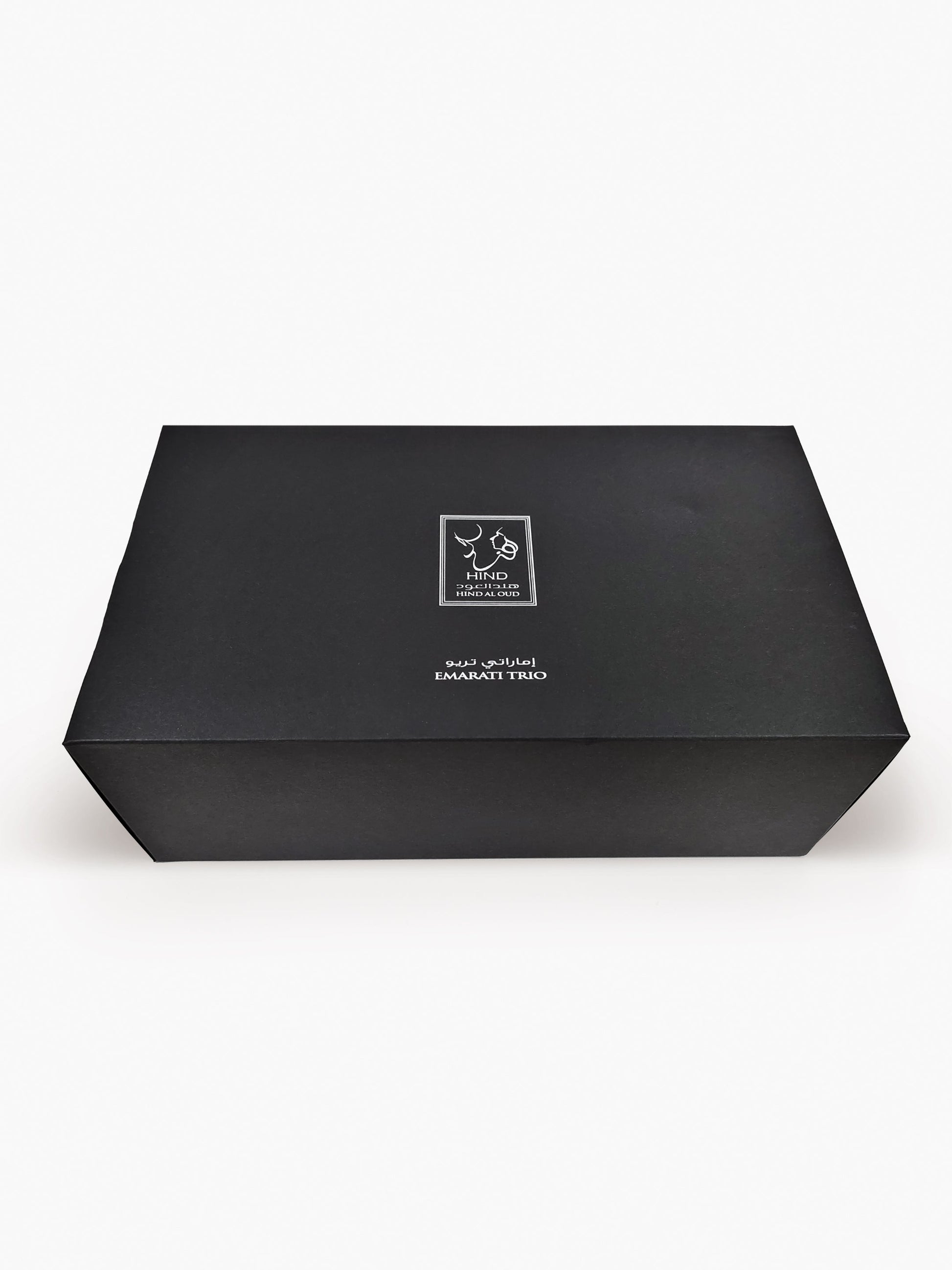 A closed, rectangular black box labeled "Emarati Musk Trio Shield Edition Gift Box - Hind Al Oud" with white Arabic and English text and the Hind Al Oud logo on the lid, set against a plain white background.