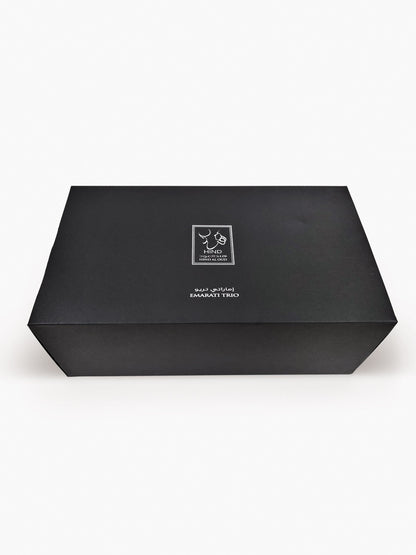 A closed, rectangular black box labeled "Emarati Musk Trio Shield Edition Gift Box - Hind Al Oud" with white Arabic and English text and the Hind Al Oud logo on the lid, set against a plain white background.