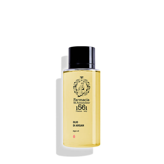 A clear bottle with a black cap, labeled Farmacia SS. Annunziata 1561 Body Argan Oil "OLIO DI ARGAN," filled with yellow argan oil, is displayed against a white background.