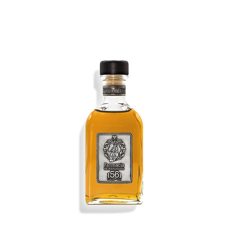 A small clear glass bottle of Giudici e Notai DIFFUSER by Farmacia SS. Annunziata 1561, with amber liquid, silver label, and black cap—ideal as a cedar wood-infused ambient diffuser for home fragrance against a white background.