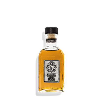 A small clear glass bottle of Giudici e Notai DIFFUSER by Farmacia SS. Annunziata 1561, with amber liquid, silver label, and black cap—ideal as a cedar wood-infused ambient diffuser for home fragrance against a white background.