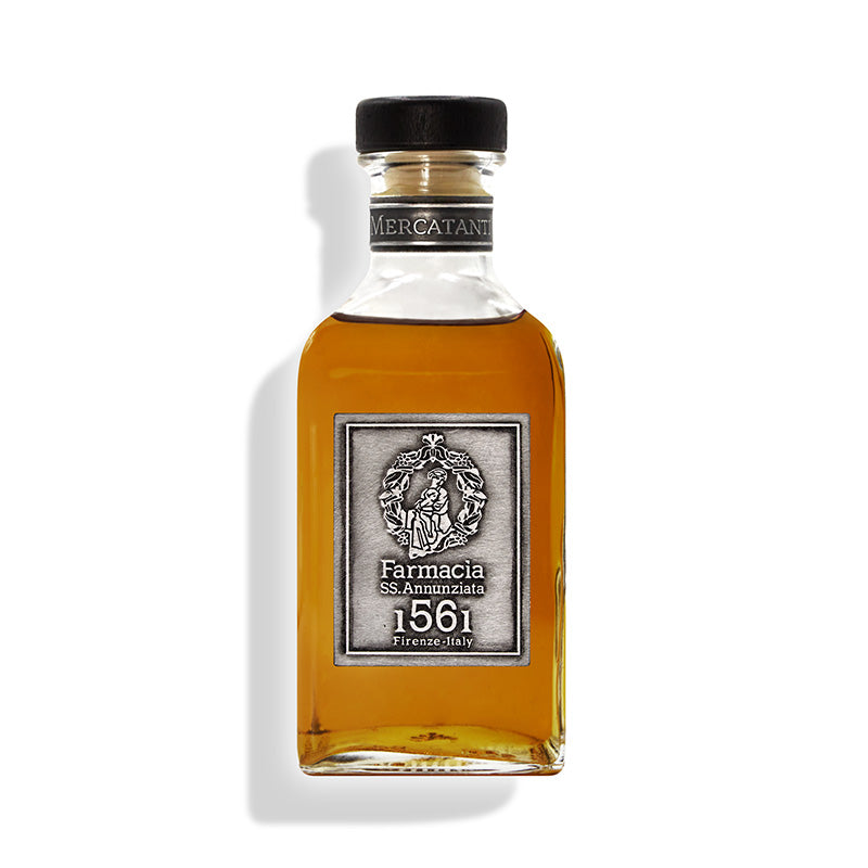 The Mercatanti Diffuser by Farmacia SS. Annunziata 1561 comes in a rectangular glass bottle with amber liquid, a black cap, and a silver label—bringing elegant oud notes and Italian heritage to your home fragrance.