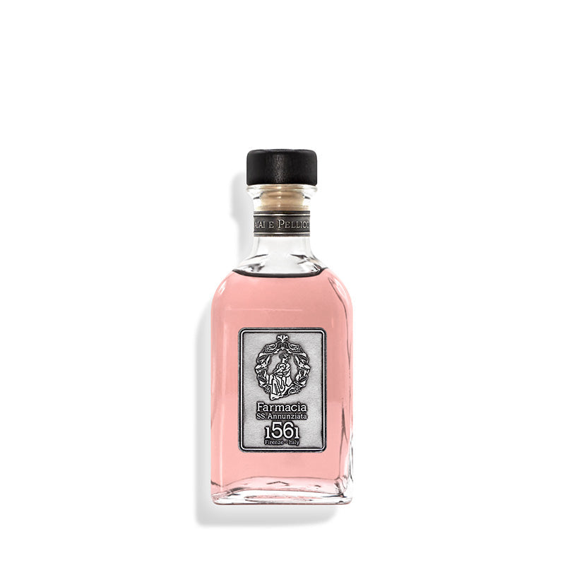 A clear glass bottle with pink liquid, black cap, and silver label reading "Farmacia SS. Annunziata 1561"—the Vaiai e Pellicciai DIFFUSER by Farmacia gently releases an elegant rosy fragrance into your space.
