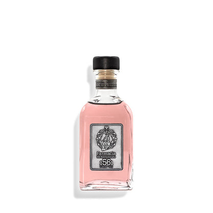 A clear glass bottle with pink liquid, black cap, and silver label reading "Farmacia SS. Annunziata 1561"—the Vaiai e Pellicciai DIFFUSER by Farmacia gently releases an elegant rosy fragrance into your space.