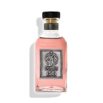 The Vaiai e Pellicciai Diffuser by Farmacia SS. Annunziata 1561 features a clear glass bottle of pink fragrance, a silver label with ornate emblem, black cap, and evokes a rosy scent—set against a white background.