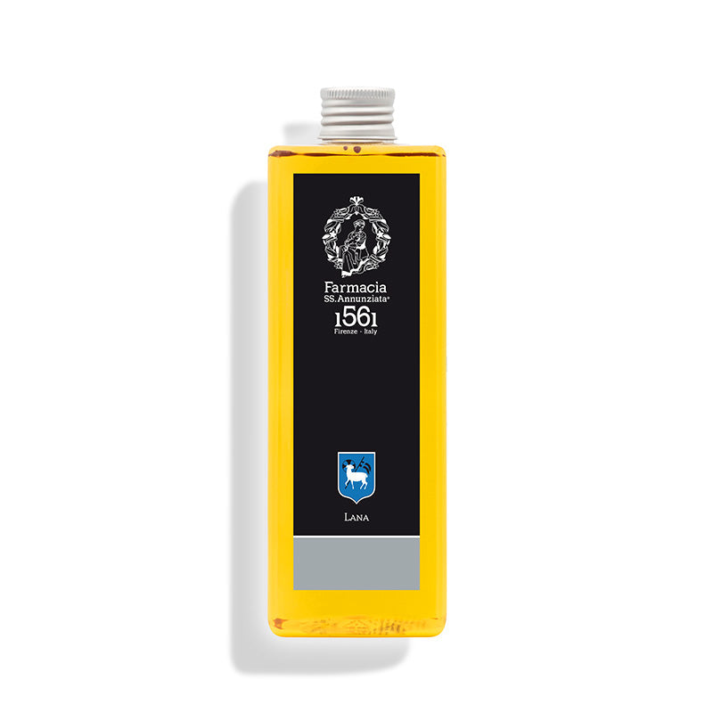 A rectangular bottle of yellow Lana REFILL by Farmacia SS. Annunziata 1561 displays a black label with ornate white text and crest, reading "Farmacia SS. Annunziata 1561 Firenze Italy" and "LANA," casting a shadow on a white background.