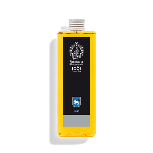 A rectangular bottle of yellow Lana REFILL by Farmacia SS. Annunziata 1561 displays a black label with ornate white text and crest, reading "Farmacia SS. Annunziata 1561 Firenze Italy" and "LANA," casting a shadow on a white background.