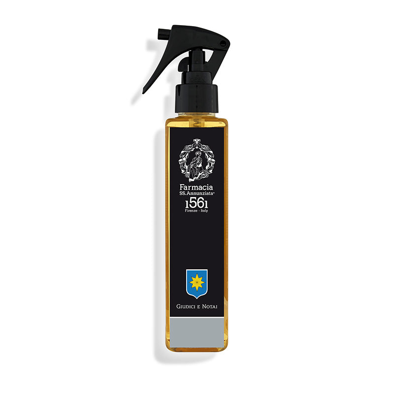 The Giudici e Notai Room Spray by Farmacia SS. Annunziata 1561 features a rectangular amber bottle with a black pump, accented by a classic label—perfect for bringing the sophisticated scent of a library to any space.