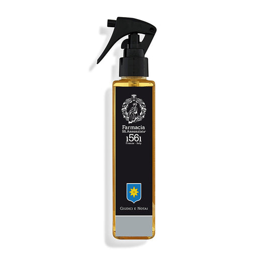 The Giudici e Notai Room Spray by Farmacia SS. Annunziata 1561 features a rectangular amber bottle with a black pump, accented by a classic label—perfect for bringing the sophisticated scent of a library to any space.