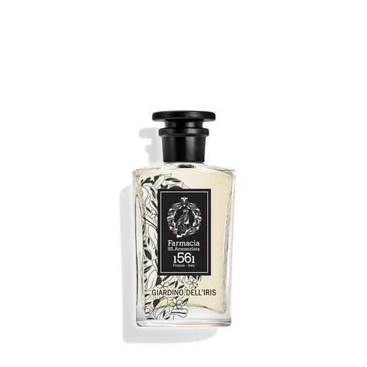 A clear bottle with a black cap, labeled Farmacia SS. Annunziata 1561 Giardino dell'Iris Eau de Parfum, features black floral designs and evokes the timeless iris scent inspired by Florence.