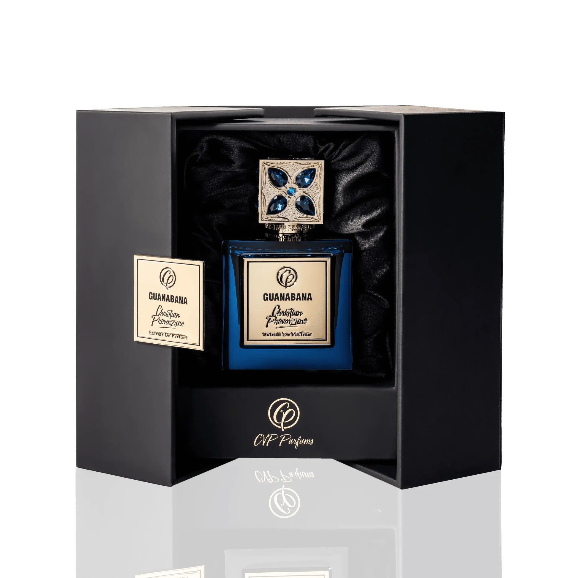 A luxurious blue perfume bottle with a jeweled silver cap sits in a black cushioned box accented in gold, featuring the Christian Provenzano logo and label “Guanabana Extrait de Parfum”—an Oriental Spicy fragrance by Christian Provenzano.