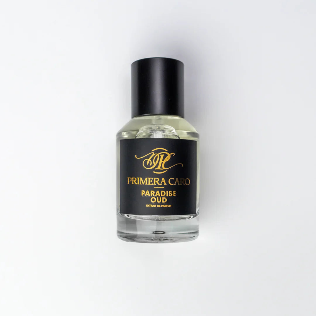 Black and gold lettering  fragrance boTTLE on white background brand PRIMERA Caro PARADISE OUD EXTRAIT DE PARFUM