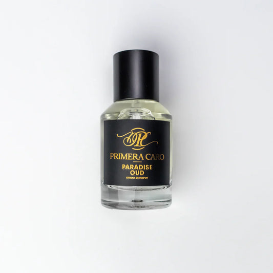 Black and gold lettering  fragrance boTTLE on white background brand PRIMERA Caro PARADISE OUD EXTRAIT DE PARFUM