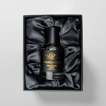Black and gold lettering  fragrance boTTLE on white background brand PRIMERA Caro PARADISE OUD EXTRAIT DE PARFUM IN VELVET FABRIC BOX 