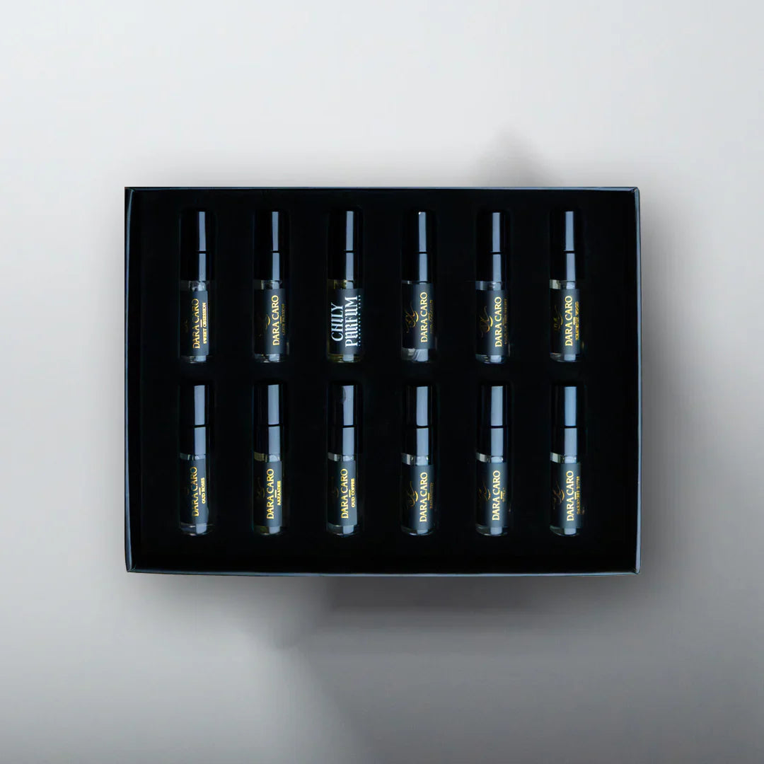 Set of eight small bottles in a black box on a light gray background