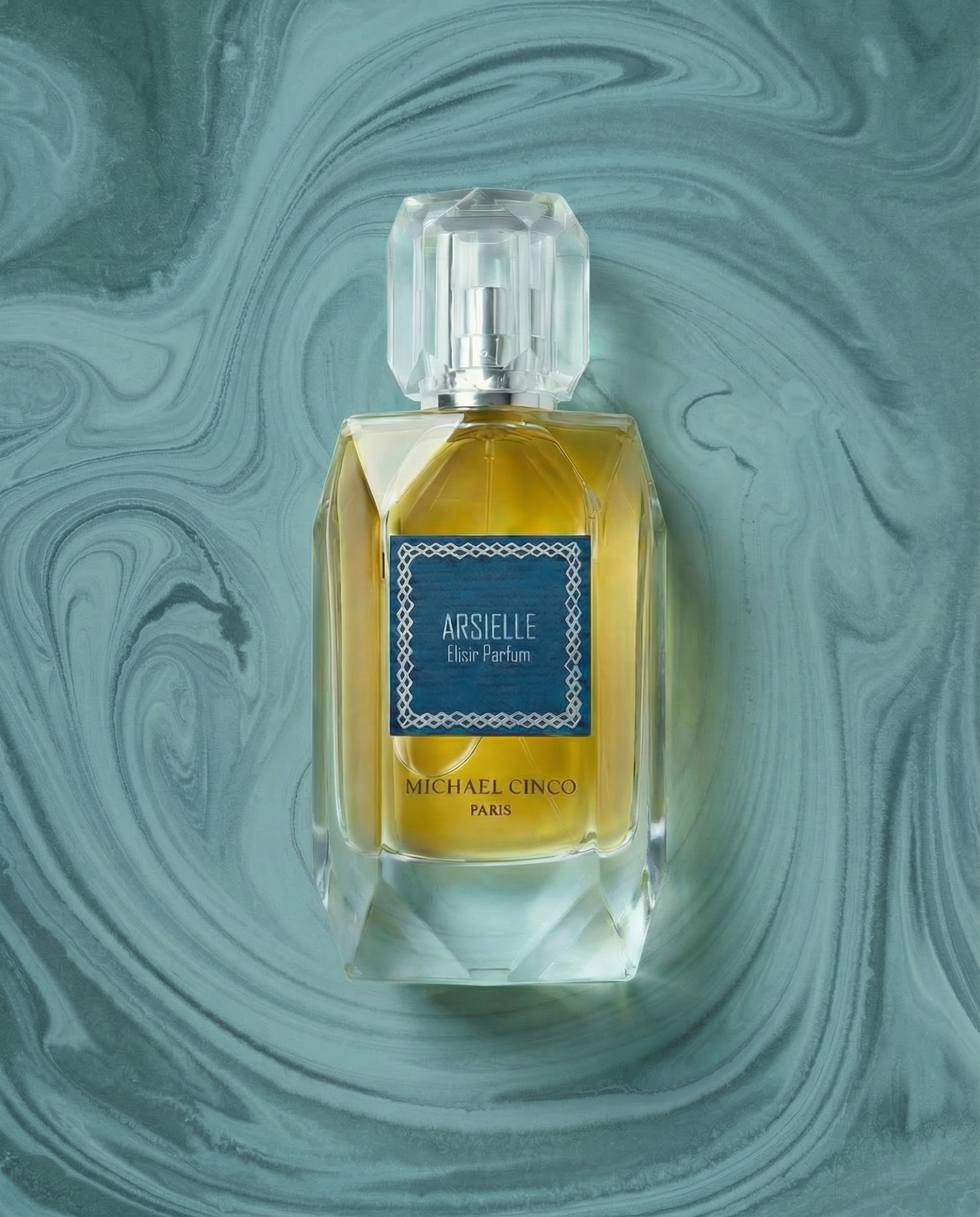 A Michael Corvo Arsielle Eau Parfum bottle with a faceted clear glass design and yellow-gold liquid, set against a swirling teal and blue marbled background.