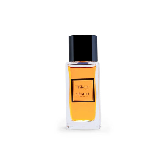 A clear rectangular bottle with amber liquid, labeled Tihota Eau de Parfum - Indult by Fragrapedia Haus and topped with a glossy black cap, sits against a white background—an enticing Tahitian vanilla scent.