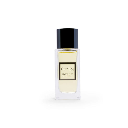 A clear glass bottle with a black cap, labeled Cuir 404 Eau de Parfum - Indult by Fragrapedia Haus, displays pale yellow liquid—highlighting this modern leather fragrance with subtle citrus notes—set against a white background.