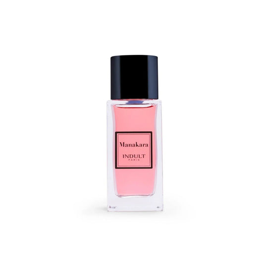 A clear glass bottle with pink liquid and a black cap, labeled Manakara Eau de Parfum - Indult by Fragrapedia Haus, sits against a white background—a lychee fragrance blending delicate fruit notes with Damascena rose.