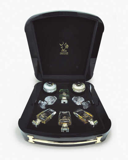 The Immortal Allure Collection Gift Set by Hind Al Oud features a black case with gold hinges displaying individually slotted Aliya'E Parfum and Barari Parfum bottles. The lid showcases a gold logo and Arabic script.
