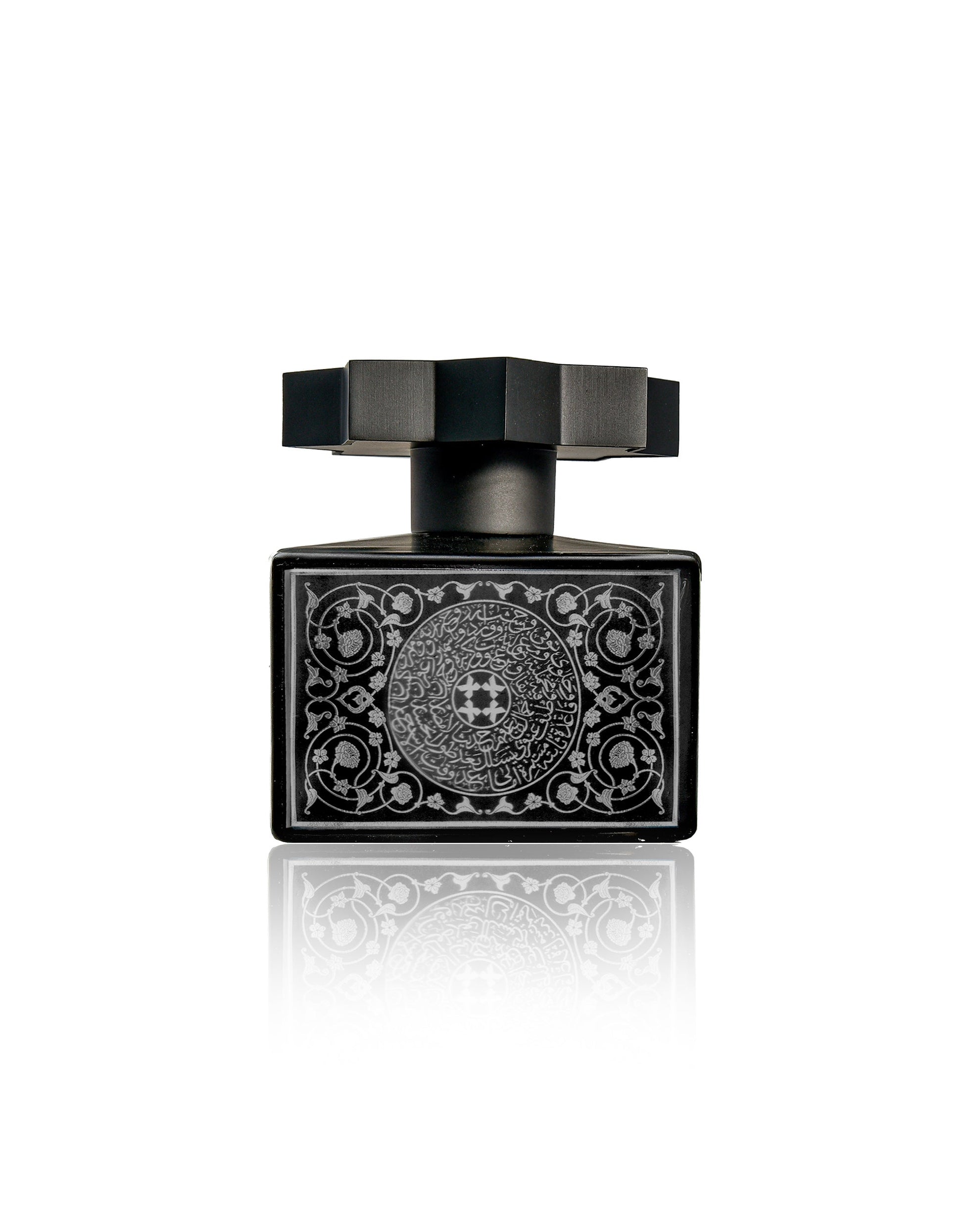 Lamar Noir Extrait de Parfum by Kajal Perfumes Paris—a black oud bottle with a geometric cap and silver floral patterns, displayed on a reflective white background—captures elegance and the essence of inner transformation.