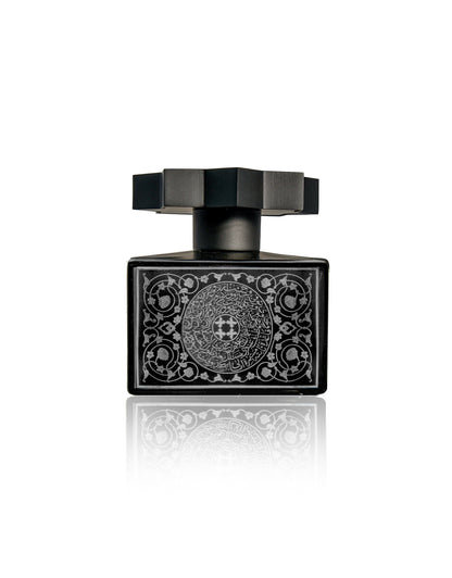Lamar Noir Extrait de Parfum by Kajal Perfumes Paris—a black oud bottle with a geometric cap and silver floral patterns, displayed on a reflective white background—captures elegance and the essence of inner transformation.