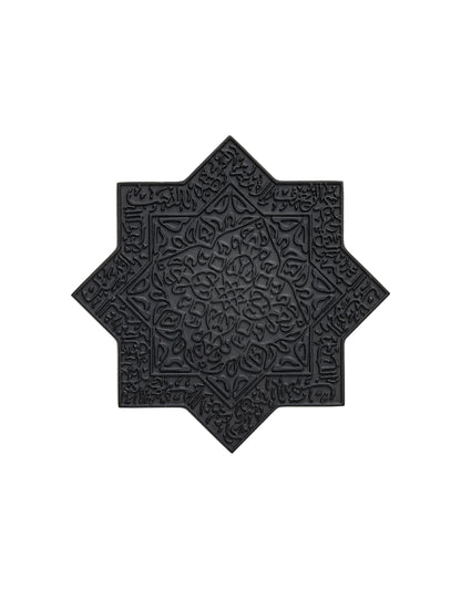 Lamar Noir Extrait de Parfum by Kajal Perfumes Paris is a black, star-shaped decorative tile with intricate Arabic calligraphy and floral engravings, evoking inner alchemy and transformation, set against a white background.