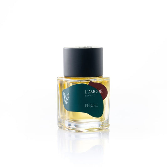 A glass bottle of L'Amour EDP by Fennec, featuring a dark green and burgundy design inspired by the North African desert and a black cylindrical cap, is set against a white background.